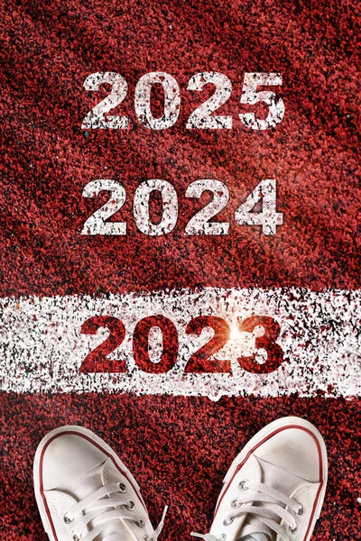 2023, 2024 and 2025 written on red sport track with starting line. Future ahead challenge concept and planning idea