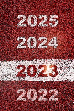 2023, 2024 and 2025 written on red sport track with starting line. Future ahead challenge concept and planning idea