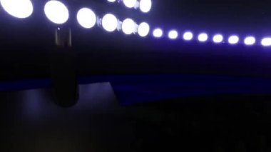 Spor stadyumunun arka planı, yanıp sönen ışıklar. Parlayan stadyum ışıkları