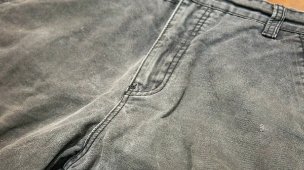 Gri kot pantolonunu fermuarla kapat. Seçici odaklanma. Sığ alan derinliği.