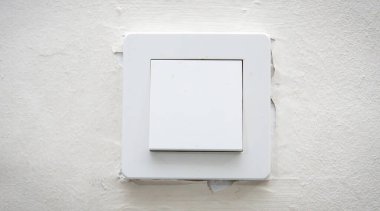 Beyaz boyalı arka plandaki elektrik şalterinin ön görüntüsü.