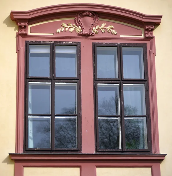 Zdobione stare czerwone okna na elewacji — Zdjęcie stockowe