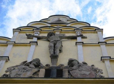 çarmıha gerilmiş İsa heykeli ile tarihi binanın ön yüzü