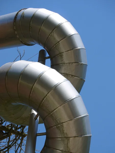 Twisted aluminium construction pipes against blue sky — Stock Photo, Image