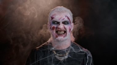 Yara izi ve lensleri olan zombi adam kameraya bakıp dişlerini gıcırdatarak korkutmaya çalışıyor.