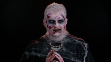 Cadılar Bayramı zombisi kostümlü kurnaz, yaralı suratlı, korkutmaya çalışan sinsi bir adam.