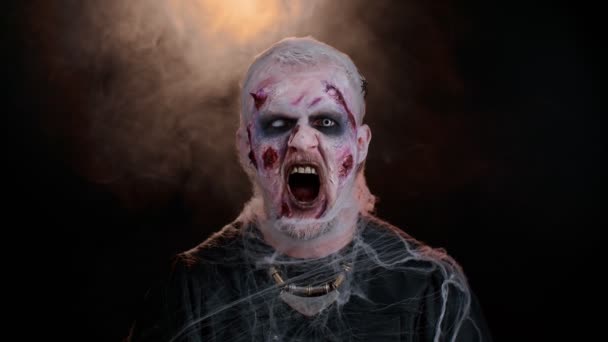 Zlověstný muž v kostýmu šíleného Halloweena zombie s krvavými jizvami tvář křičí, křičí — Stock video