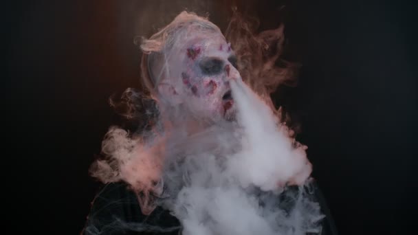 Creepy man scary wounded Halloween undead guy blows smoke from nose and mouth, smiles terribly — Stock Video