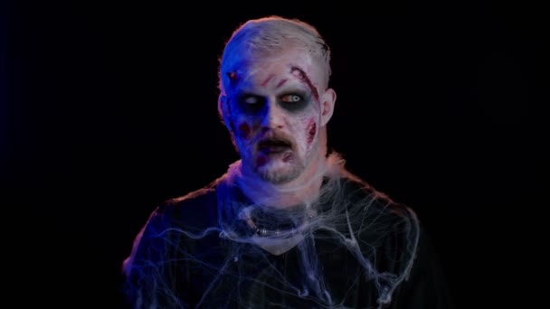 Baljós ember Halloween őrült zombi véres sebhelyekkel arc ijedt rendőri fények megadják magukat — Stock videók