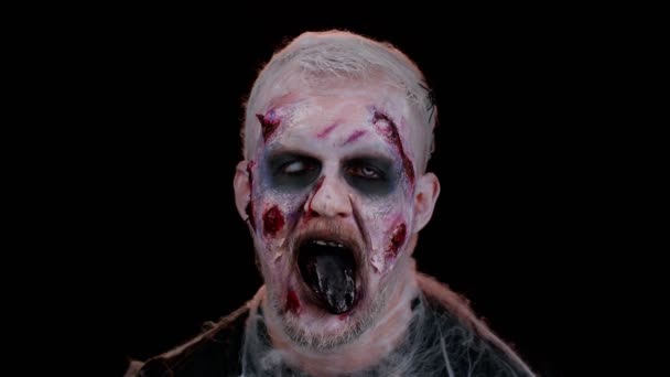 Ijesztő ijesztő ember Halloween zombi véres sebesült smink, bemutató nyelv, megpróbálja megijeszteni — Stock videók