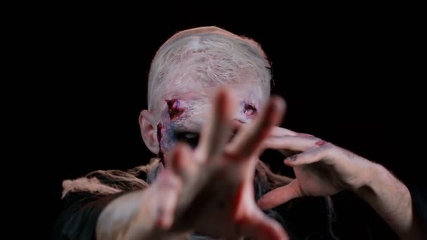 Zombie w konwulsjach z makijażem z fałszywymi ranami blizny w białych soczewkach kontaktowych próbuje przestraszyć — Wideo stockowe