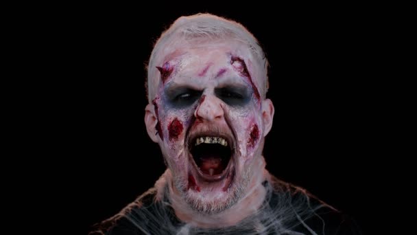 Hombre siniestro Halloween zombie loco con cicatrices heridas sangrientas cara tratando de asustar a la habitación negra — Vídeos de Stock