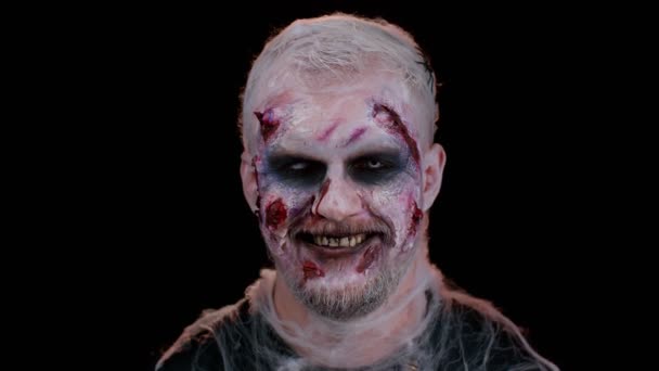 Játékos baljós ember Halloween őrült zombi véres sebhelyek arc pislogó szem fogas mosoly — Stock videók