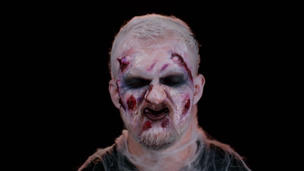 Straszny ranny nieumarły Halloween człowiek zombie robi miny, uśmiecha się strasznie, i klika zębami — Wideo stockowe