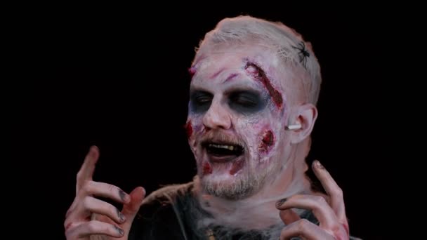 Zombie-Mann mit Wundnarben im Gesicht trägt Kopfhörer, hört Musik, tanzt, feiert — Stockvideo