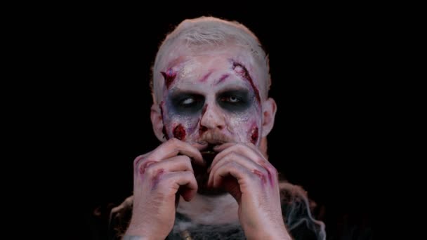 Zombie hombre con maquillaje con heridas falsas cicatrices vómitos bitcoins de oro, minería criptomoneda btc — Vídeos de Stock