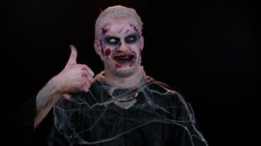 Kötü adam Cadılar Bayramı zombisi bir şeye katılıyor ya da olumlu cevap veriyor.