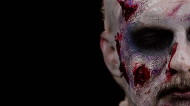Wajah dekat dari orang jahat dengan riasan zombie Halloween yang mengerikan terlihat menyeramkan di depan kamera — Stok Video