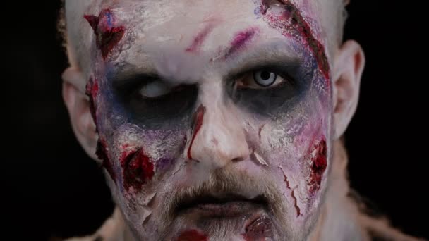 Przerażający człowiek przerażające ranne blizny twarz Halloween nieumarły facet dmucha dym z nosa, uśmiecha się — Wideo stockowe