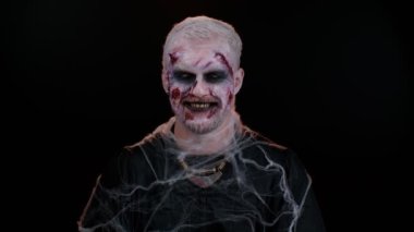 Cadılar Bayramı zombisi, işaret parmağını dudaklarına bastırıyor. Sessiz jest işareti yapıyor.