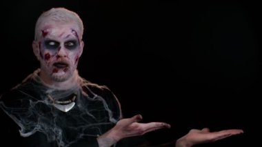 Cadılar Bayramı zombisi, ticari metin logosu için boş bir yeri işaret ediyor.