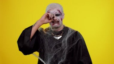 Üzgün cadılar bayramı zombisi adam gözyaşlarını siliyor ve umutsuzluktan ağlıyor, haksız şeyler yüzünden üzgün.