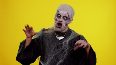 Şeytani adam korkunç cadılar bayramı zombisi şakacı, aptal yüz ifadeleri yapıyor, suratını buruşturuyor.