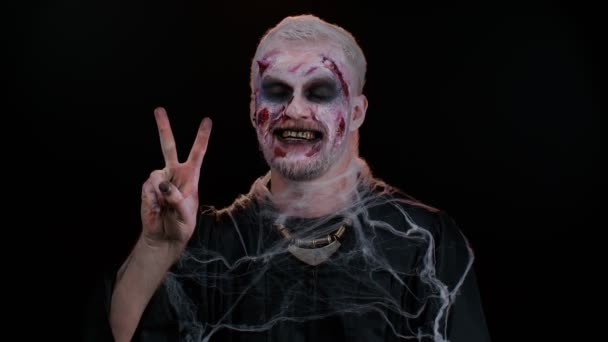 Halloween homem zumbi sangrento make-up mostrando sinal de vitória, esperando para o sucesso e ganhar o gesto de paz — Vídeo de Stock