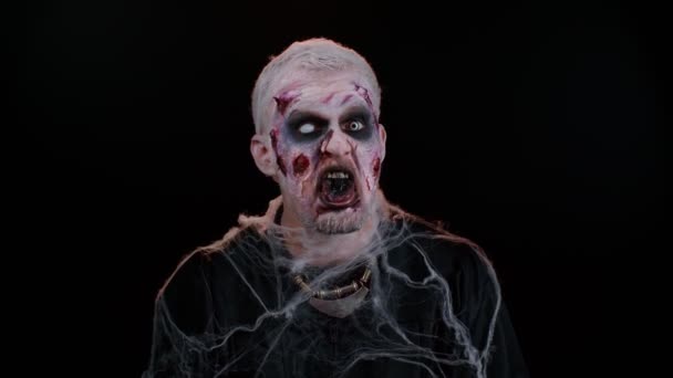 Sinistere man eng Halloween zombie het maken van speelse domme gezichtsuitdrukkingen grimmig geklooi rond — Stockvideo