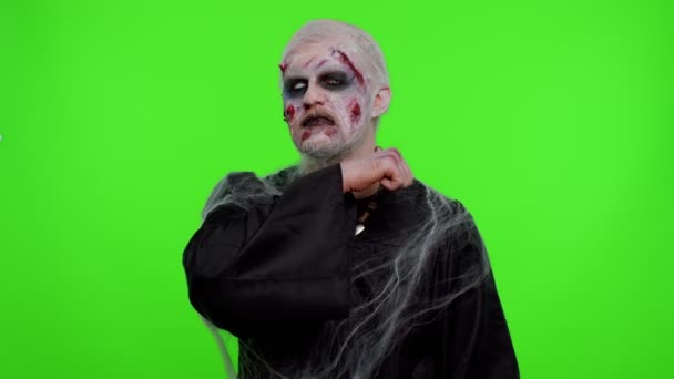 Sinister man Halloween zombie trying to scare showing killing gesture, runs a finger along his neck — Stock Video