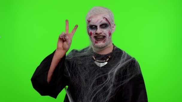 Halloween zombie man bloody make-up showing victory sign, hoping for success and win peace gesture — Stock Video