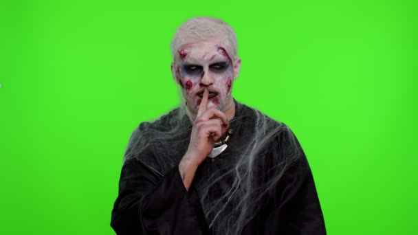 Хэллоуин зомби человек прижимает указательный палец к губам делает знак молчания жеста не рассказывает секрет — стоковое видео