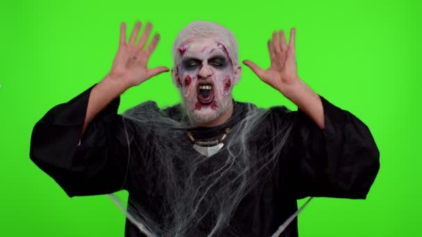 Ondskefulla man skrämmande Halloween zombie gör lekfulla dumma ansiktsuttryck grimacing lura runt — Stockvideo