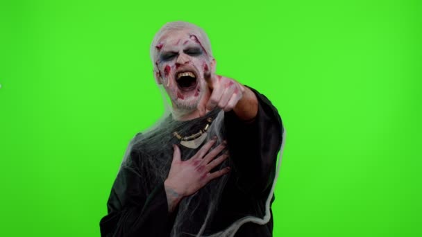 Halloween-Zombie-Mann zeigt mit dem Finger auf Kamera, lacht laut, spottet und macht lustige Witze — Stockvideo