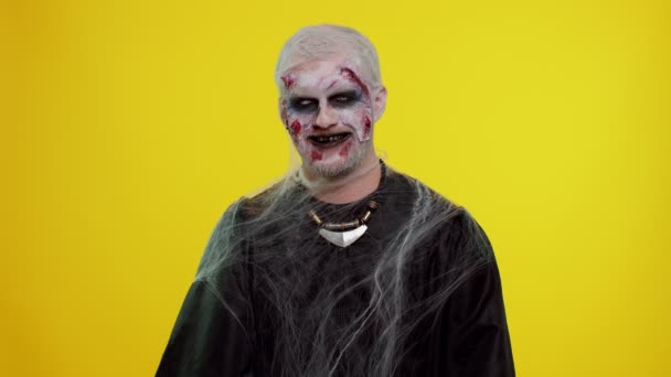 Vesel înfiorător om Halloween zombie face fețe, se uită la camera foto, zâmbește teribil cu dinți murdari — Videoclip de stoc