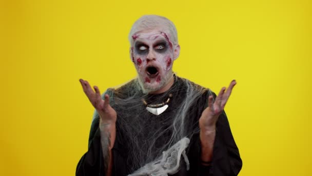Gruseliger Mann Halloween-Zombie hebt überrascht die Hände und wirkt schockiert über plötzlichen Sieg — Stockvideo