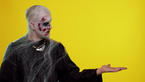 Straszny ranny zombie Halloween nieumarły człowiek pokazuje kciuki w górę i wskazując w prawo na pustej przestrzeni — Wideo stockowe