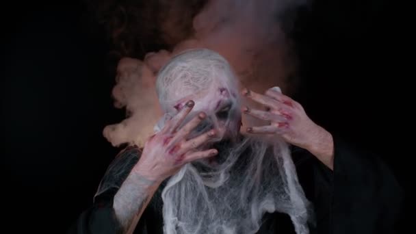 Zombie mayat hidup yang terluka menakutkan membuat wajah, bersembunyi melalui jaring laba-laba, tersenyum sangat, takut — Stok Video