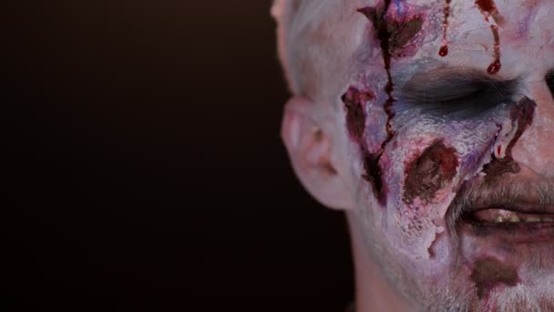 Zombie άνθρωπος μακιγιάζ πρόσωπο με πληγές ουλές και λευκό φακούς επαφής αίμα ρέει και στάζει στο πρόσωπο — Αρχείο Βίντεο