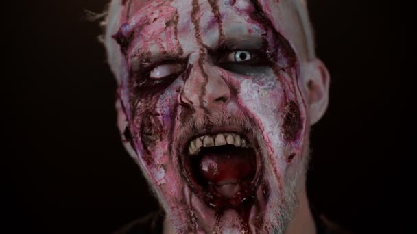 Zombie man face makeup with wounds scars and white contact lenses blood flows and drips on face — Stock Video