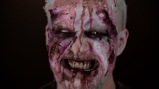 Espeluznante cara de hombre con Halloween zombie maquillaje herido sangriento, sangre fluye y gotea en la cara — Vídeo de stock