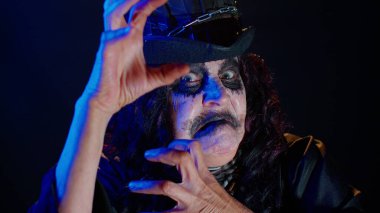 Cadılar Bayramı cadı makyajlı korkunç kadın kameraya bakıyor, korkutmaya çalışıyor, yüz ifadeleri.