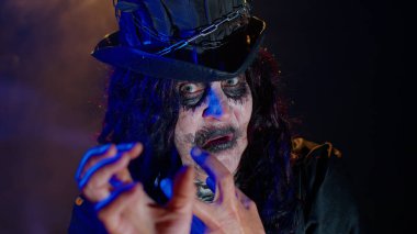 Korkunç korkunç cadılar bayramı cadı makyajlı yaşlı kadın kostümünü giyip korkutmaya çalışıyor.