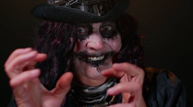 Cadılar Bayramı cadısının karnaval kostümlü, yaşlı, uğursuz kadını korkutmaya çalışıyor.