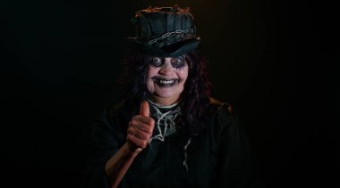 Korkunç Cadılar Bayramı cadı makyajlı uğursuz yaşlı kadın baş parmağını kaldırıyor.