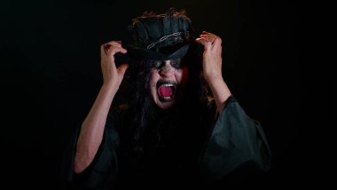 Cadılar Bayramı kostümlü uğursuz yaşlı kadın stres yüzünden çığlık atıyor. Korku umutsuzluğu hissediyor.