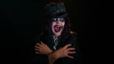 Cadılar Bayramı kostümlü ürkünç yaşlı kadın stres yüzünden çığlık atıyor. Korku umutsuzluğu hissediyor.