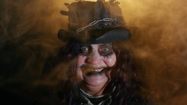 Cadılar Bayramı cadısının karnaval kostümü içinde suratını asıp korkutmaya çalışan yaşlı, uğursuz bir kadın.