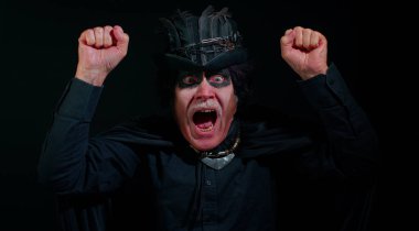 Cadılar Bayramı kostümlü uğursuz yaşlı adam stres yüzünden çığlık atıyor. Korku umutsuzluğu hissediyor.