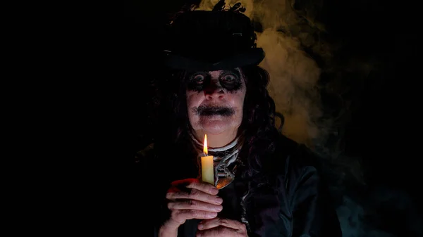 Finstere Frau mit gruseliger Halloween-Hexe im Kostüm, die Voodoo-magische Rituale mit Kerze macht — Stockfoto